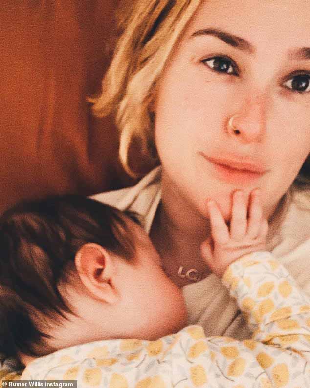Связывание: Следующей была милая фотография молодой мамы, держащей на руках свою дочь.  Румер была одета в белую футболку, и у нее было мечтательное выражение лица.  Младенец был одет в бело-желтый комбинезон и держал одну руку на подбородке своей мамы.