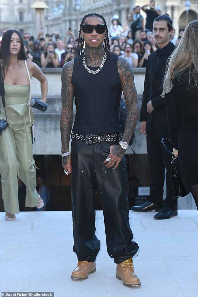 Принимаем участие: рэпер Tyga продемонстрировал свои сильно татуированные руки, шею и грудь в черном жилете, когда он прибыл накануне мероприятия.