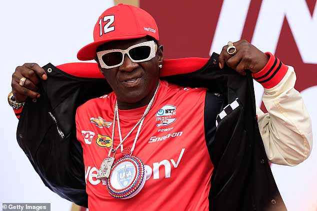 Рэпер Flavor Flav также был сфотографирован до того, как сильный дождь задержал старт гонки.