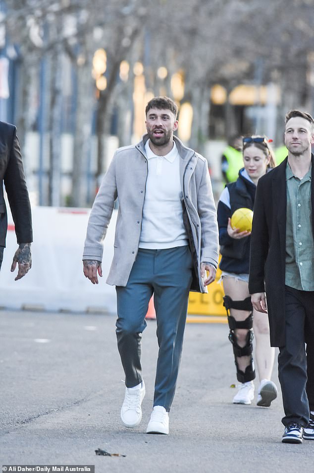 Билли, 31 год, выбрал стиль smart-casual, накинув светло-серое пальто на белую рубашку-поло.
